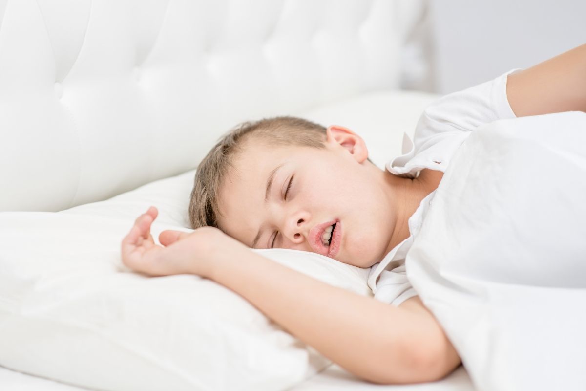 Niño durmiendo con la boca abierta — ronquido infantil y respiración oral